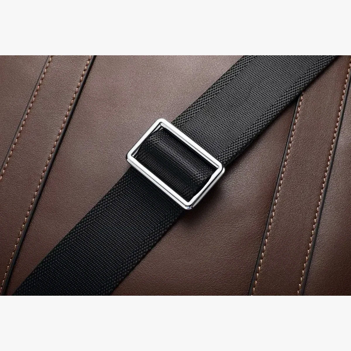 Détail des poignées en cuir marron et fermeture zippée