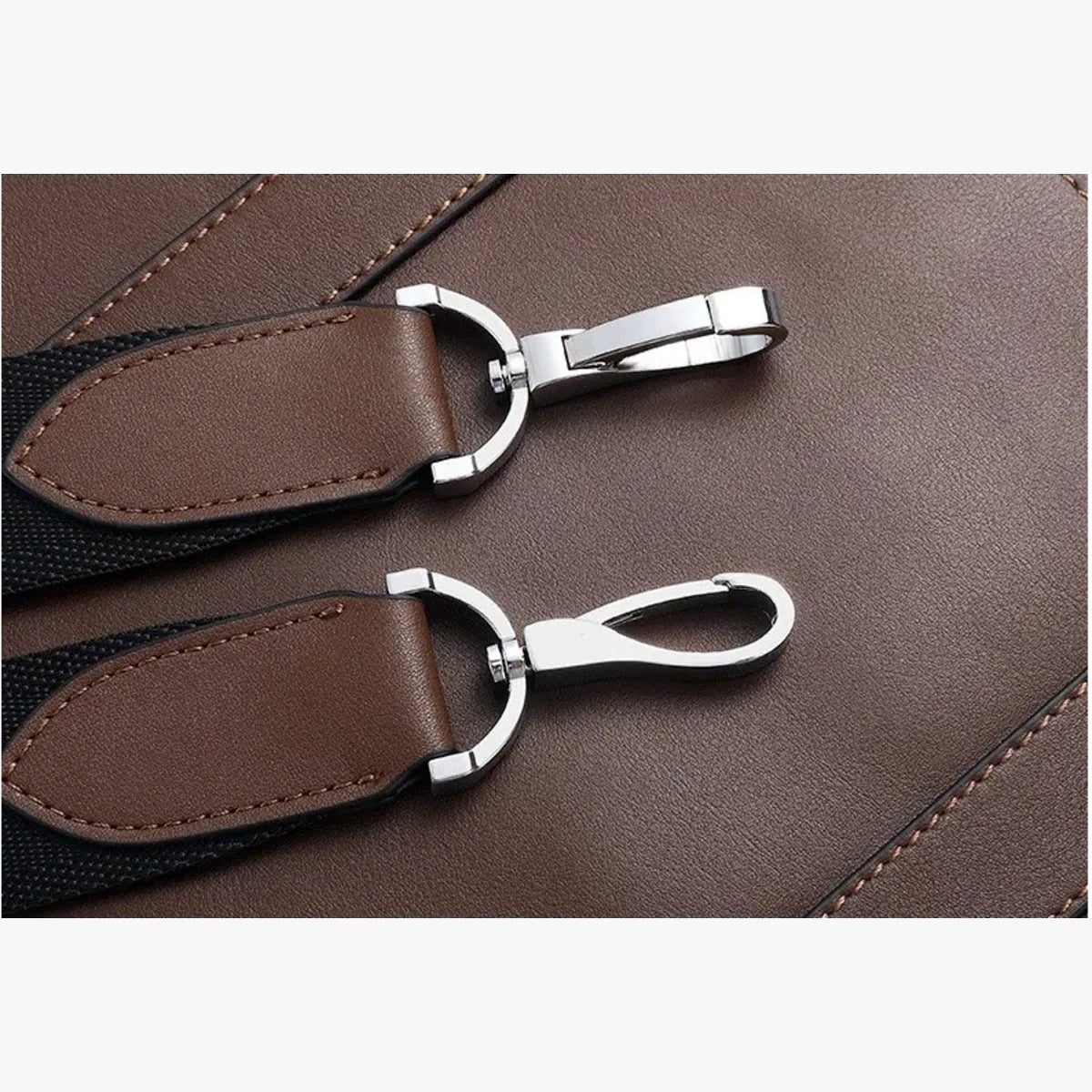 Détail couture et attaches métalliques sur cuir marron