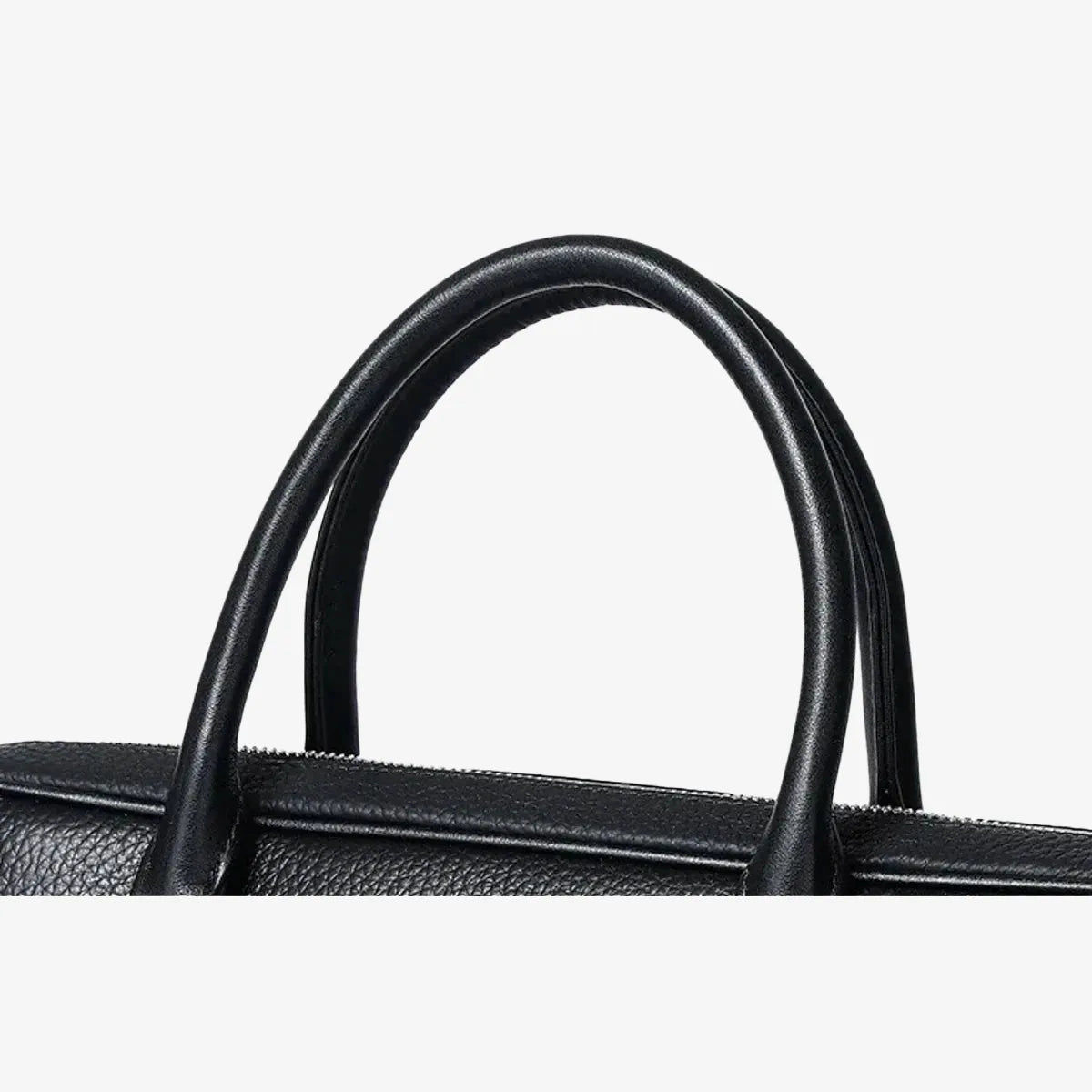 Détail des poignées en cuir noir du porte-documents avec couture visible