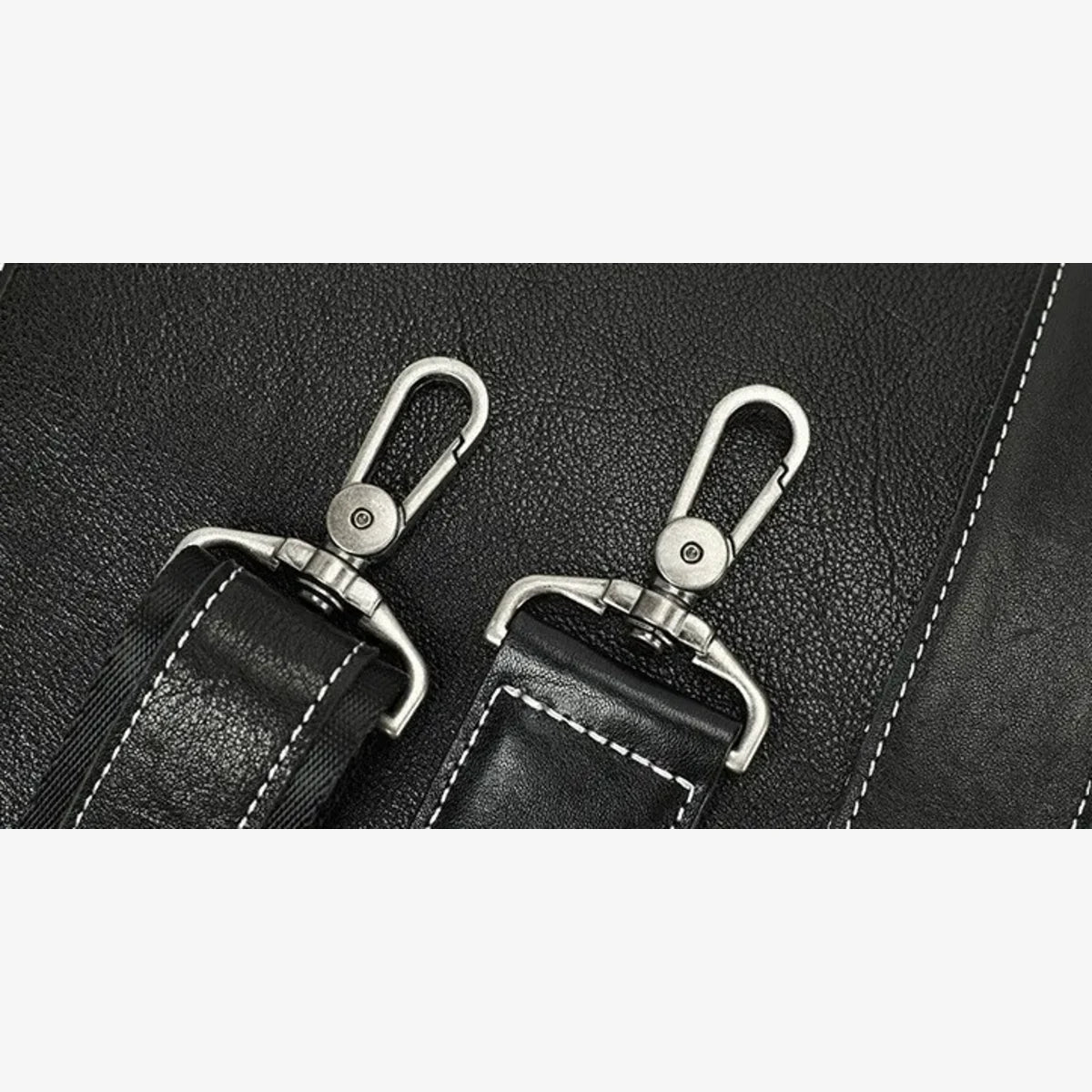 Détail des attaches métalliques sur la bandoulière du porte-documents en cuir noir