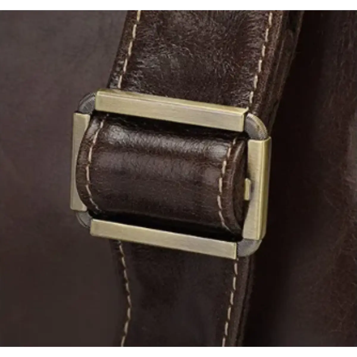 Détail de la boucle en métal doré sur la bandoulière en cuir du porte-documents